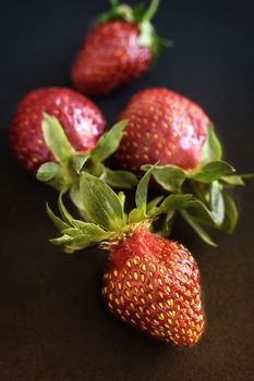 On a black background ripe red strawberry berries close-up.