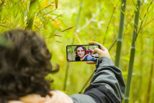 Kakheti, Georgia - November 12, 2020: Woman takes self photo, mobile phone and nature background