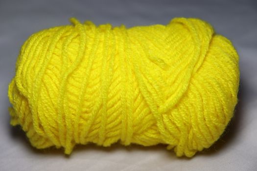 yellow colored yarn closeup on white background