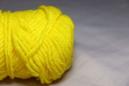 yellow colored yarn closeup on white background