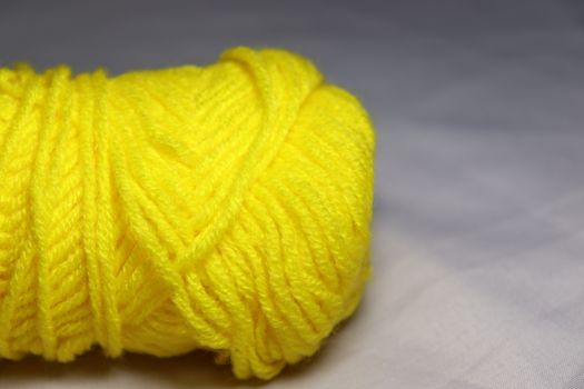 yellow colored yarn closeup on white background