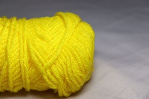 yellow colored yarn closeup on white background