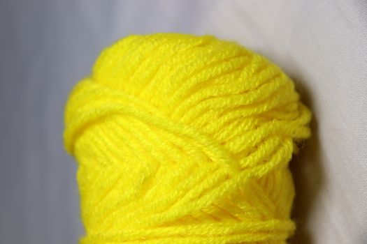 yellow colored yarn closeup on white background