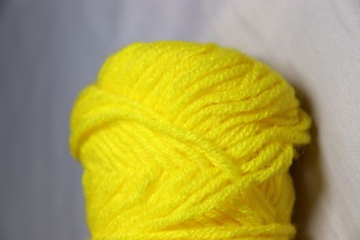 yellow colored yarn closeup on white background