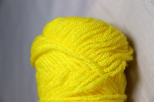 yellow colored yarn closeup on white background