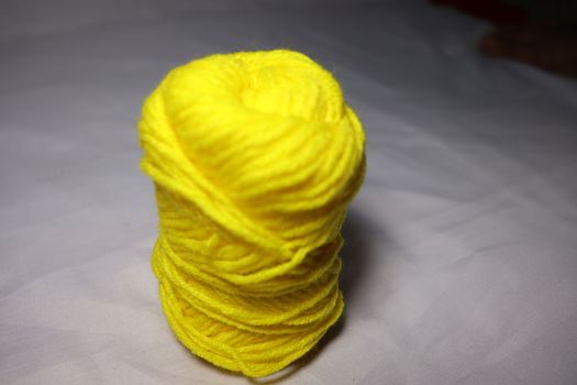 yellow colored yarn closeup on white background