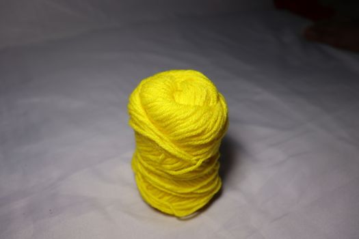 yellow colored yarn closeup on white background