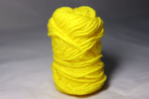 yellow colored yarn closeup on white background