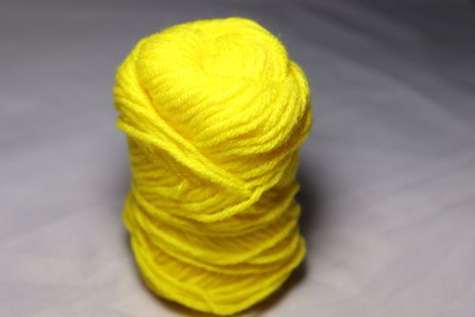 yellow colored yarn closeup on white background