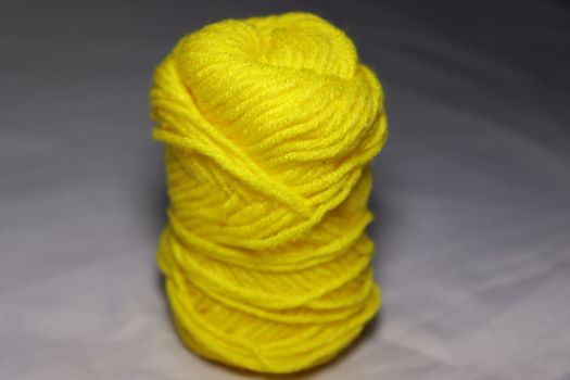 yellow colored yarn closeup on white background