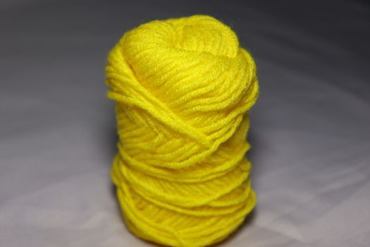 yellow colored yarn closeup on white background