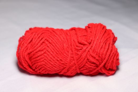 red colored yarn closeup on white background
