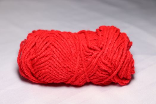 red colored yarn closeup on white background