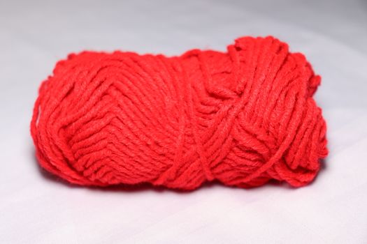 red colored yarn closeup on white background