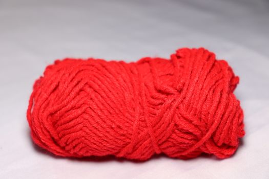 red colored yarn closeup on white background