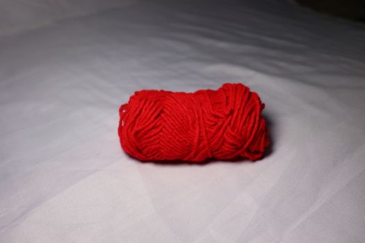 red colored yarn closeup on white background