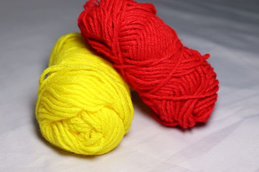 red and yellow colored yarn closeup on white background
