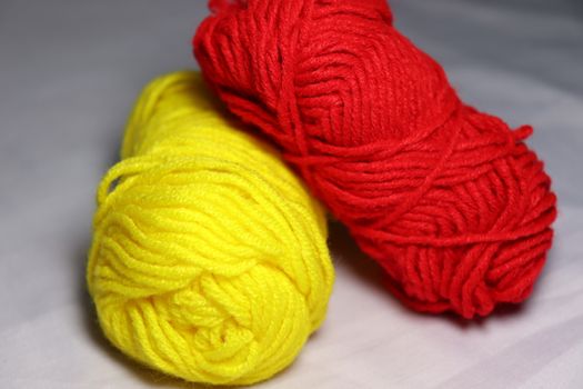 red and yellow colored yarn closeup on white background