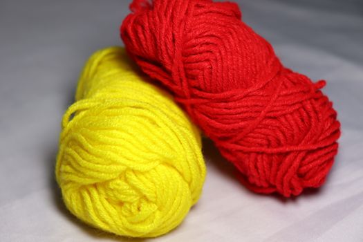 red and yellow colored yarn closeup on white background