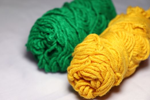 green and yellow colored yarn closeup on white background