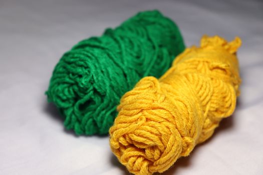 green and yellow colored yarn closeup on white background