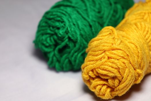green and yellow colored yarn closeup on white background