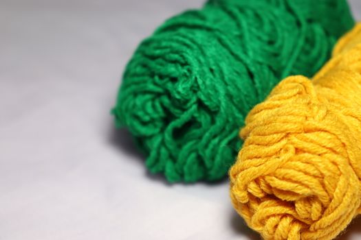 green and yellow colored yarn closeup on white background