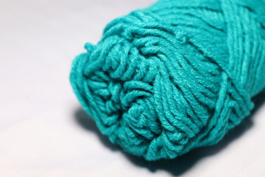 cyan colored yarn closeup on white background