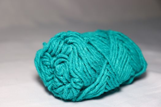 cyan colored yarn closeup on white background