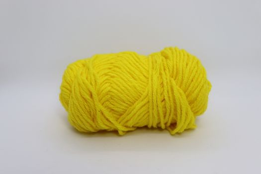 yellow colored yarn closeup on white background