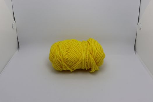 yellow colored yarn closeup on white background