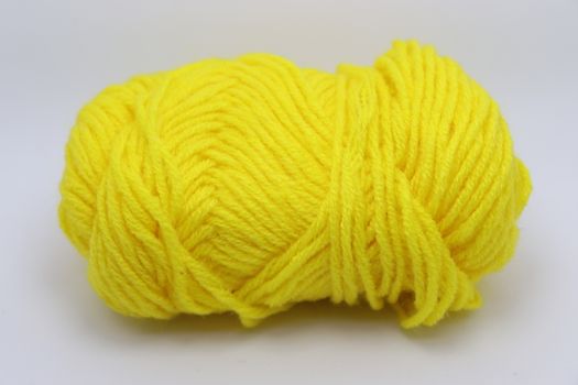 yellow colored yarn closeup on white background