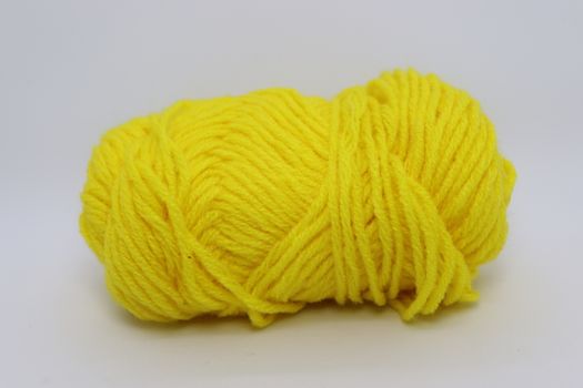 yellow colored yarn closeup on white background