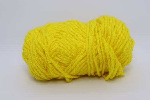yellow colored yarn closeup on white background