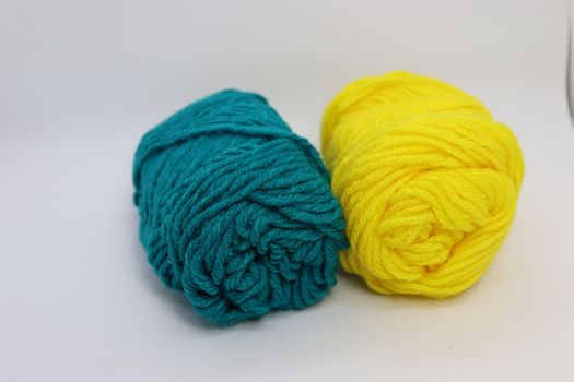 yellow and cyan colored yarn closeup on white background