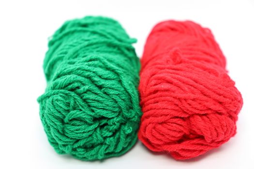 red and green colored yarn closeup on white background