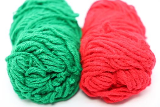 red and green colored yarn closeup on white background