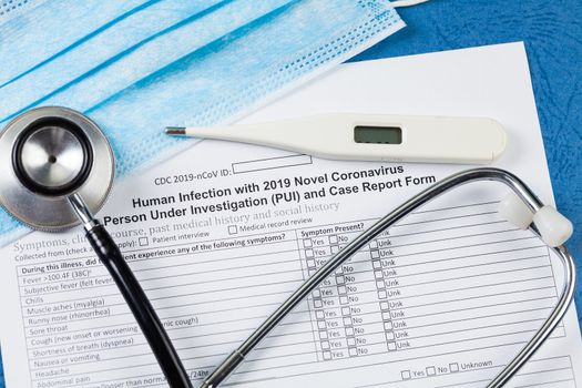 Stethoscope, thermometer, blue surgical face mask and self reporting form, Coronavirus COVID-19 pandemic crisis outbreak, testing and quarantine isolation of travellers 