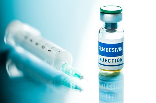 REMDESIVIR injection ampoule with syringe & needle,isolated on reflective glass surface,potential FDA experimental trial drug for treating Coronavirus COVID-19 virus disease cases,pandemic crisis cure