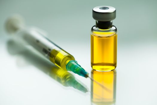 Syringe with needle & vial ampoule with yellow liquid,illustration of potential vaccine for Coronavirus,groundbreaking cure & therapy for COVID-19 virus disease,SARS-CoV-2 remedy & immunization,W.H.O.