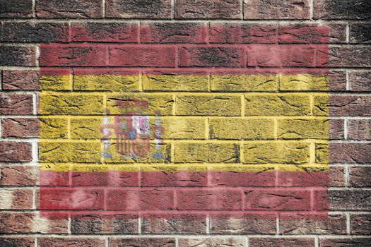A Spain flag on a brick wall background
