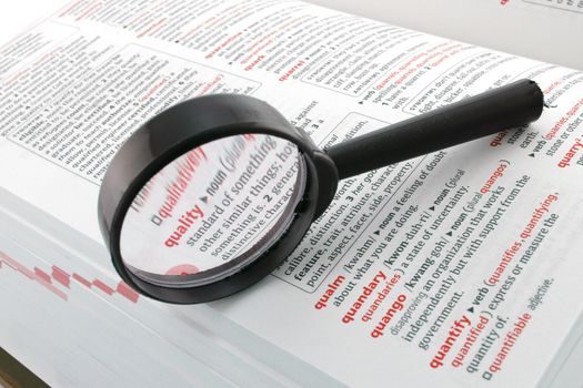 A magnifying glass focussed on the word quality. Quality assurance control enhancement business concept