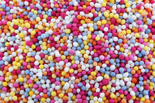 Some hundreds and thousands sprinkles tiny sugar beads of varying colours used for decorating cakes and desserts background texture