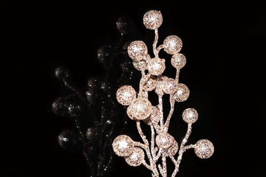 shiny branch with balls reflected in black glass close up