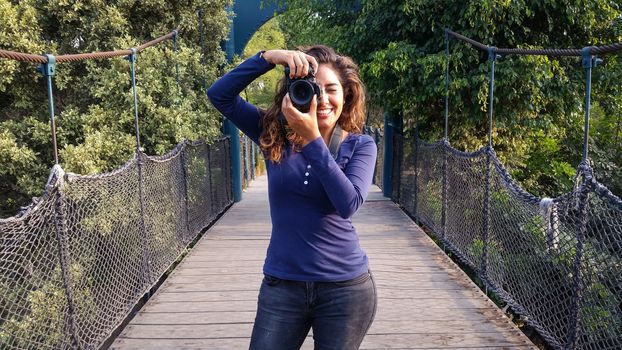 Outdoor summer smiling lifestyle portrait of pretty young woman having fun in the city of Lima taking pictures with her camera