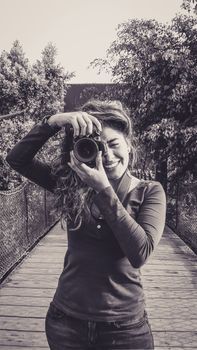 Outdoor summer smiling lifestyle portrait of pretty young woman having fun in the city of Lima taking pictures with her camera