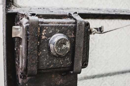 Old metal lock latch and a glass door bar