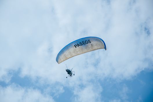 Man in paraglider with blue sky, in whose paraglider he says the following: rides
