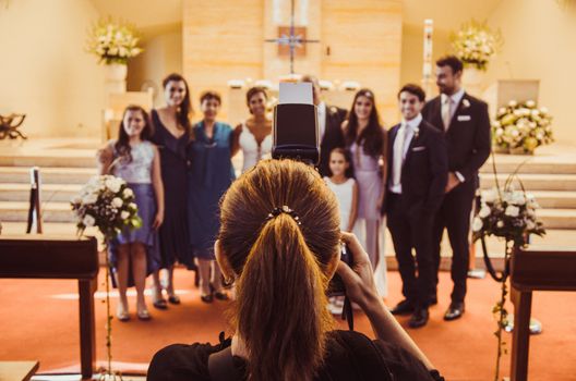 Professional wedding photographer in action in a church