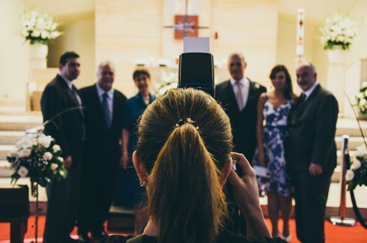 Professional wedding photographer in action in a church